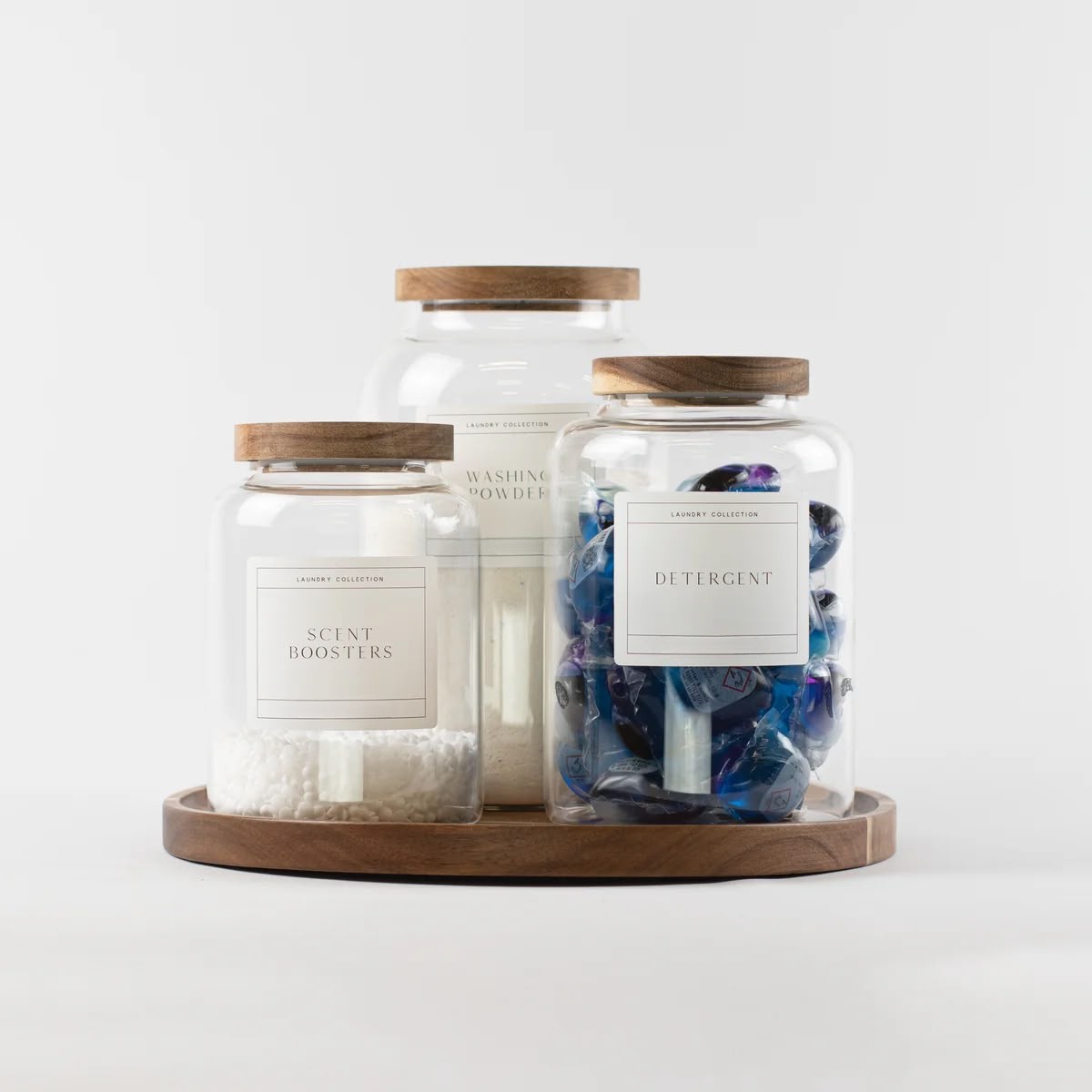 Laundry jars holding detergent, scent boosters and washing powder on a round wooden turntable